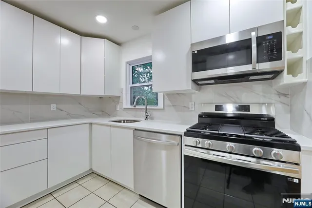 a kitchen with stainless steel appliances granite countertop a stove and a microwave