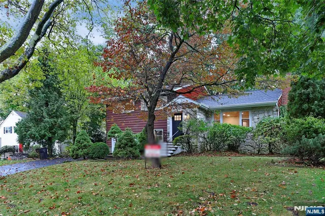 a house is sitting in middle od the grass