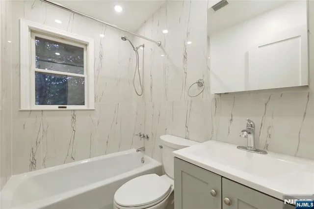 a bathroom with a sink toilet vanity and shower