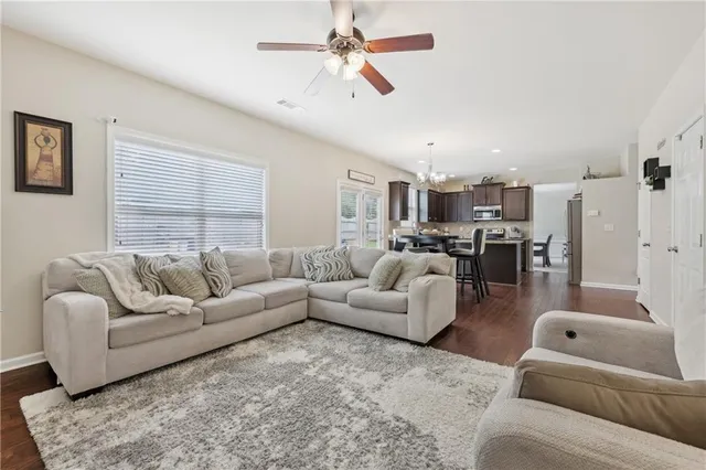 a living room with furniture kitchen view and a window