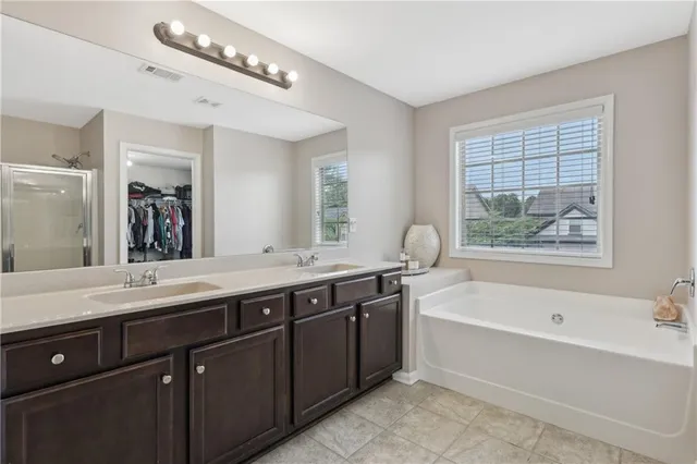 a spacious bathroom with a large tub sink and mirror