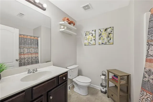 a bathroom with a sink vanity mirror and toilet