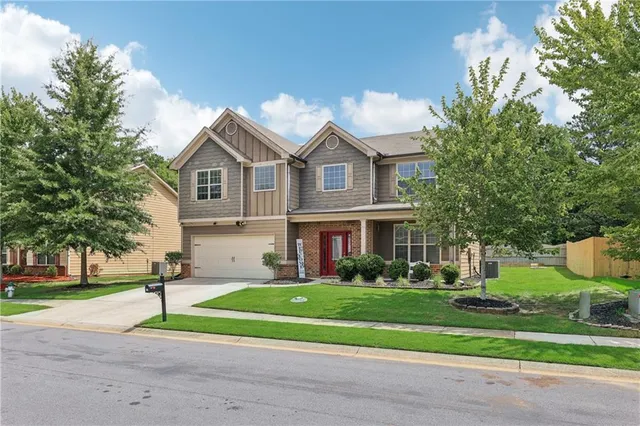 a front view of a house with a yard and trees
