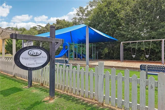 a view of a house with a small yard and a large tree