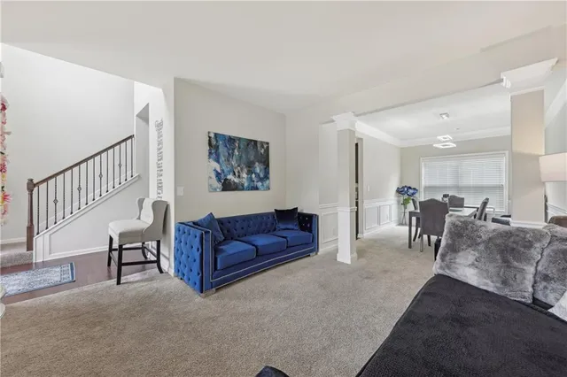 a living room with furniture and a dining table with kitchen view