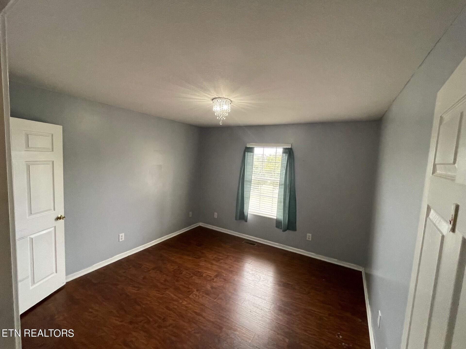 5409 Old Niles Ferry Road Maryville, TN 37801 - Photo 23 of 43 an empty room with wooden floor and windows