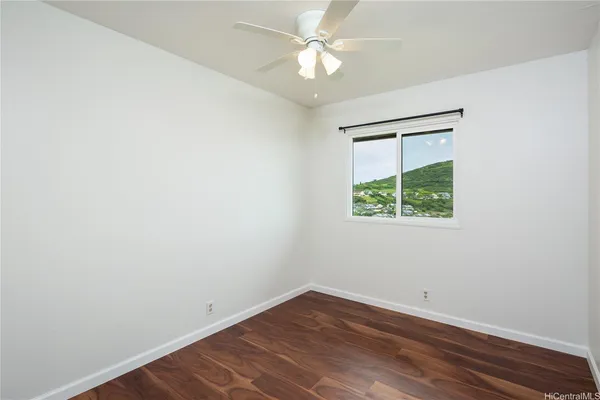 an empty room with a window and a ceiling fan