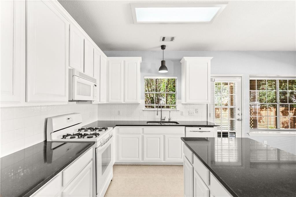 10708 Sycamore Hills Road Austin, TX 78717 - Photo 5 of 10 a kitchen with stainless steel appliances granite countertop a sink stove and cabinets