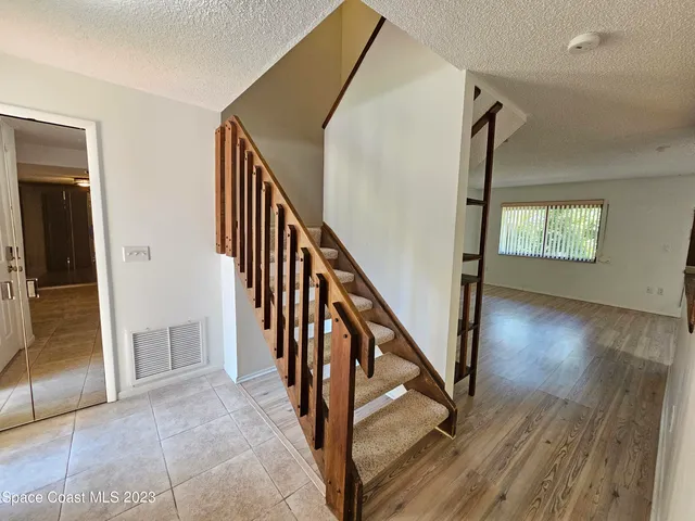 a view of an entryway with wooden floor and stairs