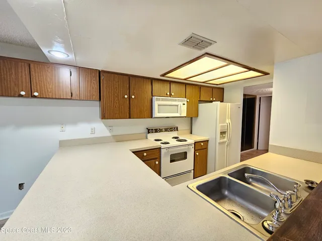 a view of a kitchen with a sink and wooden floor