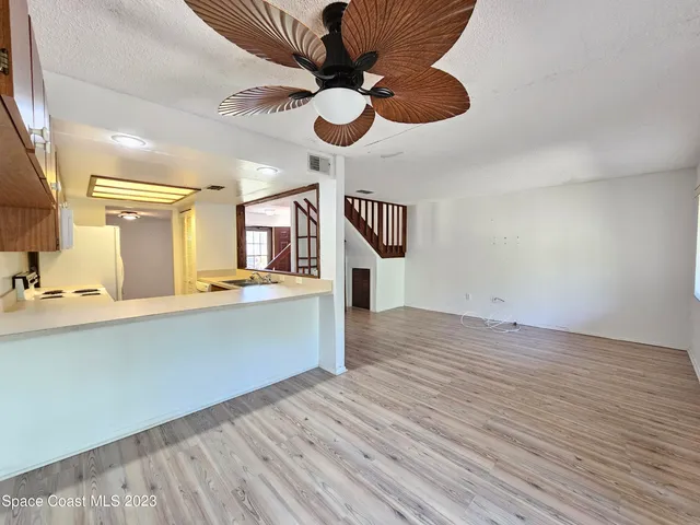 a view of a livingroom with wooden floor and stairs