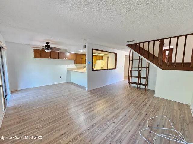 a view of a hallway with wooden floor and staircase