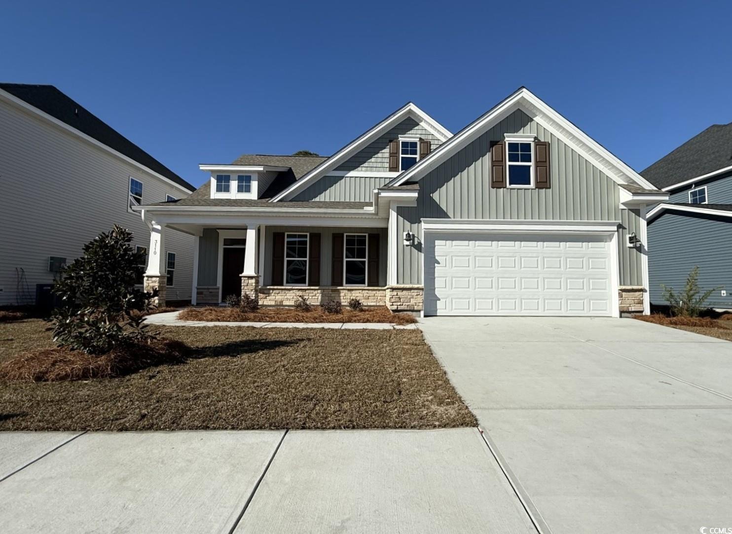 Craftsman inspired home with covered porch, board and batten siding, concrete driveway, and stone siding