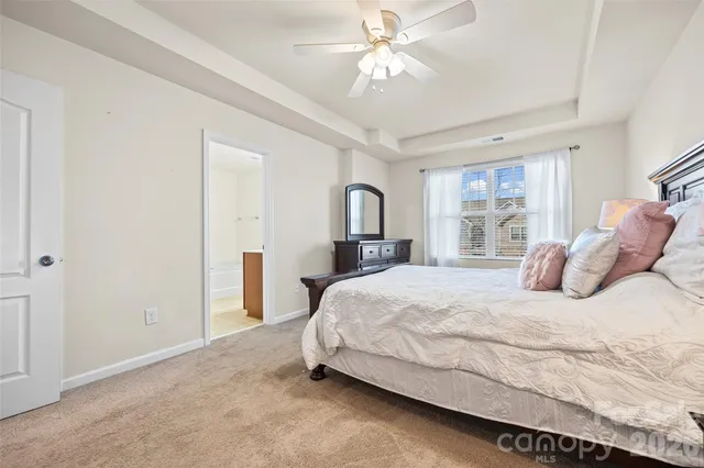 a bedroom with a large bed and a chandelier