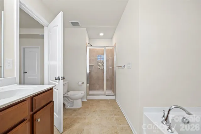 a bathroom with a granite countertop sink a toilet and shower