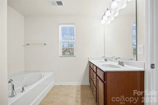 a bathroom with a tub sink and mirror