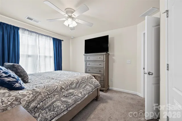 a bedroom with a bed a window and a flat screen television