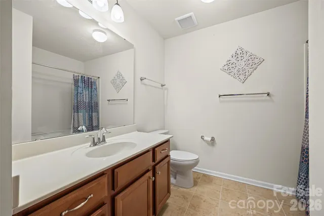 a bathroom with a sink a light fixture and a toilet