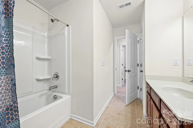 a bathroom with a tub a sink a mirror and a shower