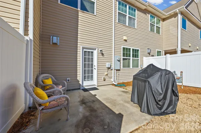 a view of backyard with seating space and wooden fence