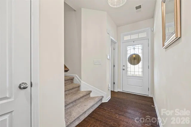 a view of a hallway with wooden floor and entryway