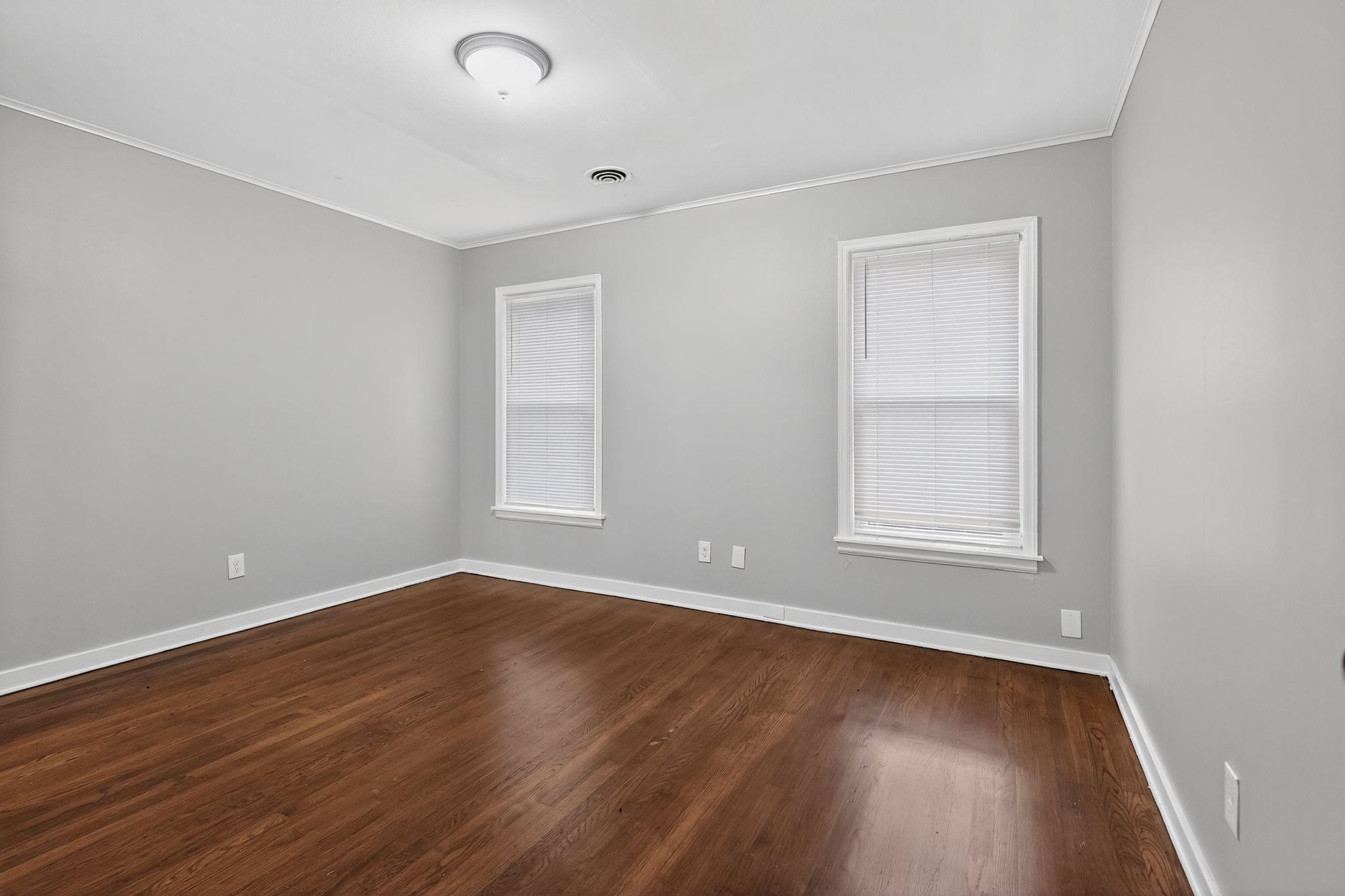 177 East Raines Road Memphis, TN 38109 - Photo 12 of 32 an empty room with wooden floor and windows