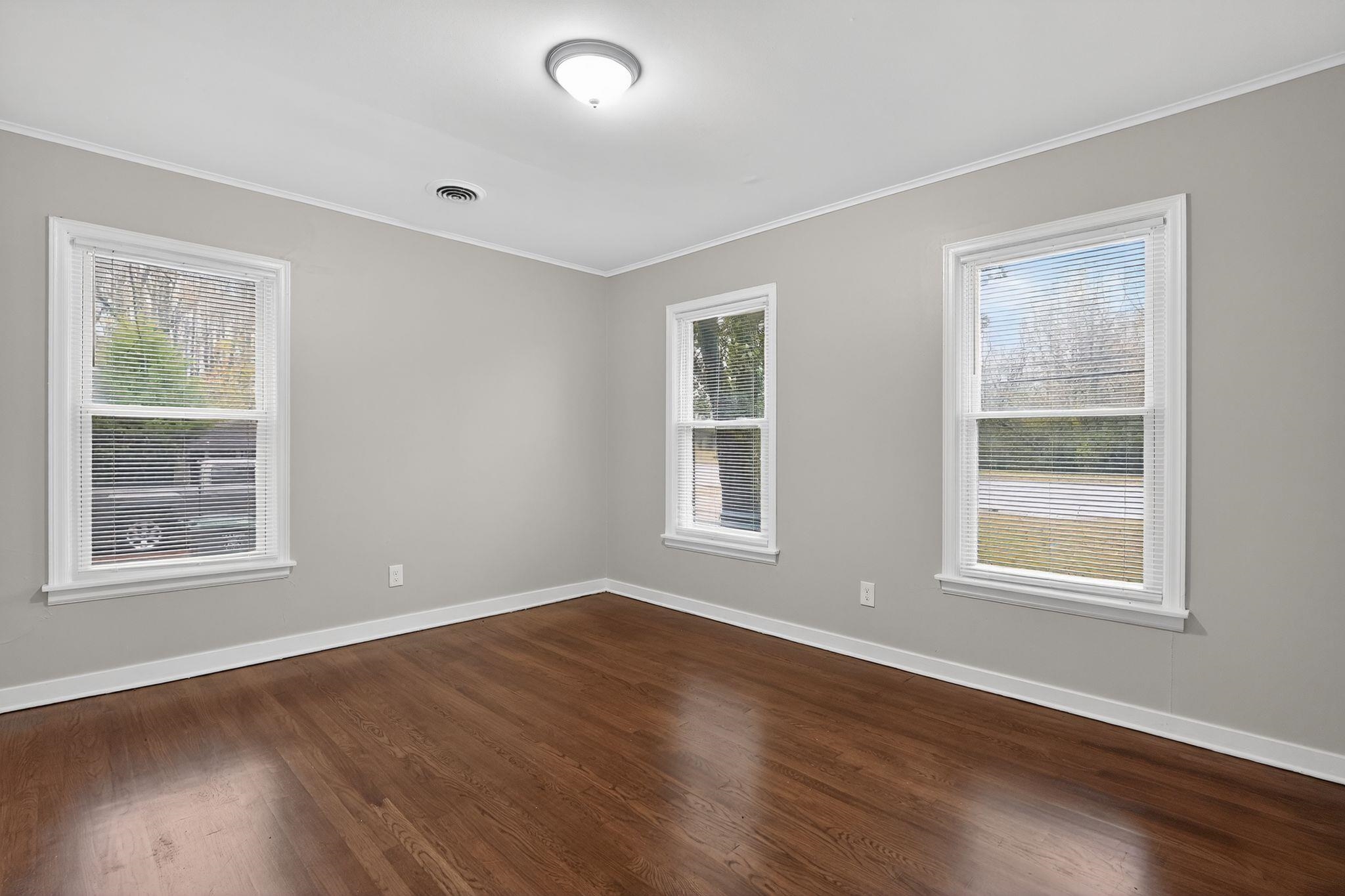 177 East Raines Road Memphis, TN 38109 - Photo 13 of 32 a view of an empty room with wooden floor and a window