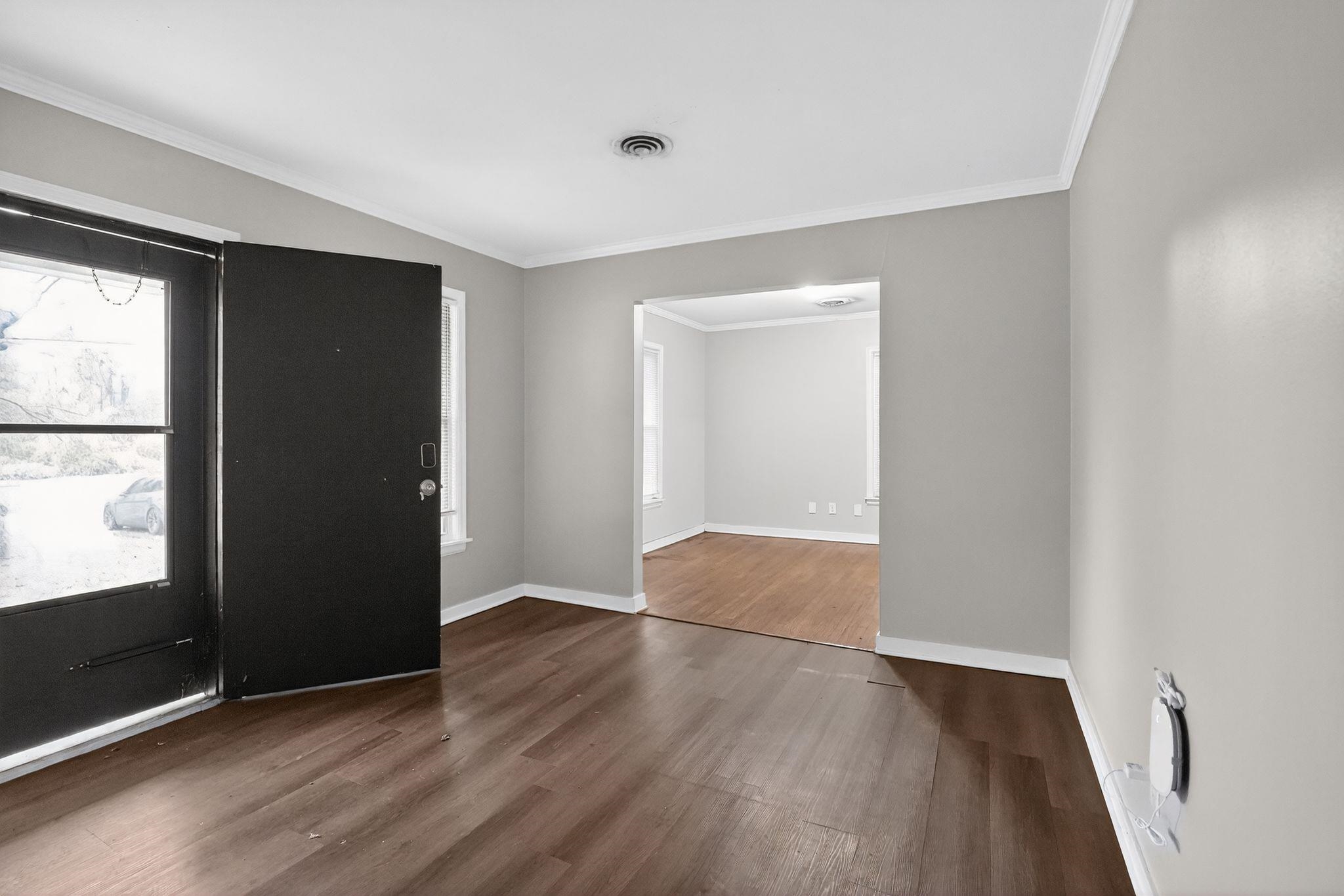 177 East Raines Road Memphis, TN 38109 - Photo 6 of 32 an empty room with wooden floor and windows