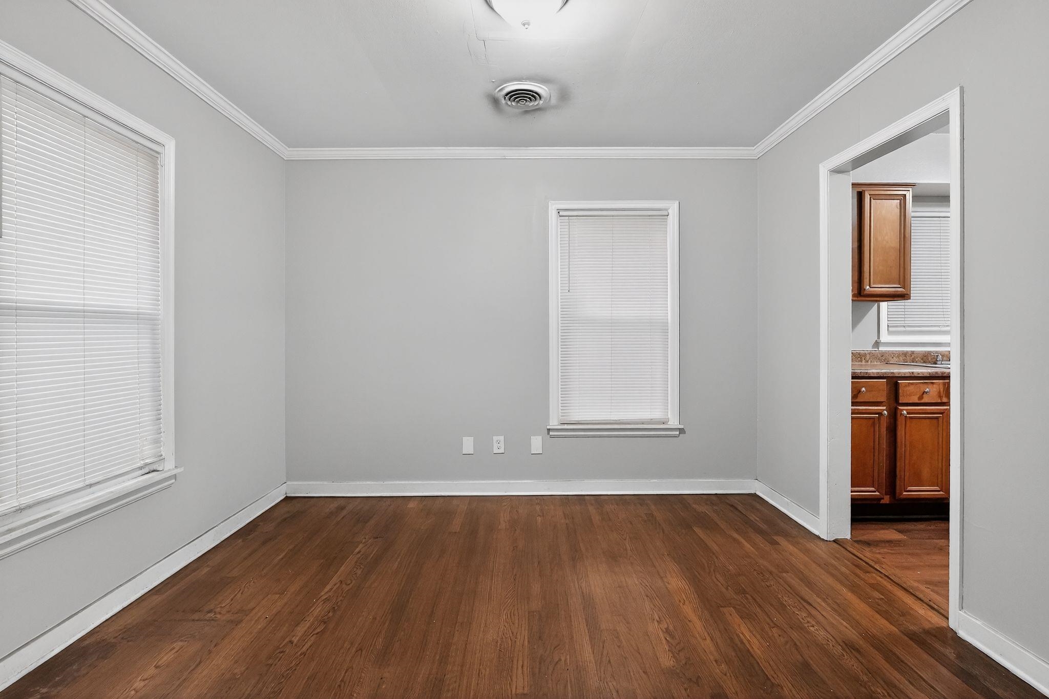 177 East Raines Road Memphis, TN 38109 - Photo 7 of 32 an empty room with wooden floor and windows