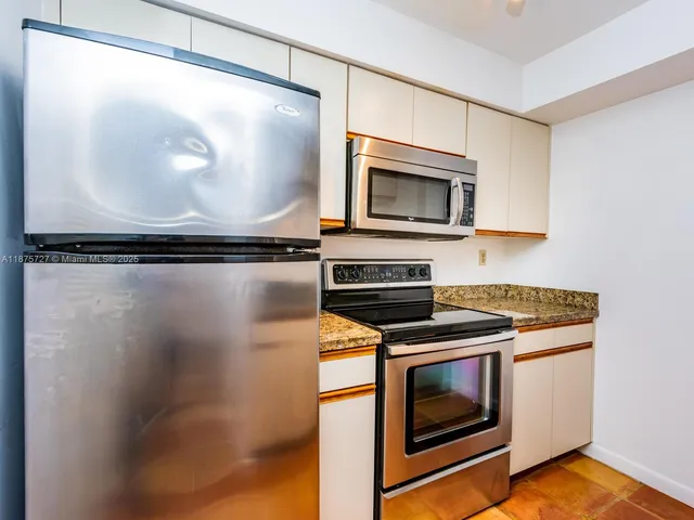 a kitchen with granite countertop a stove and a microwave