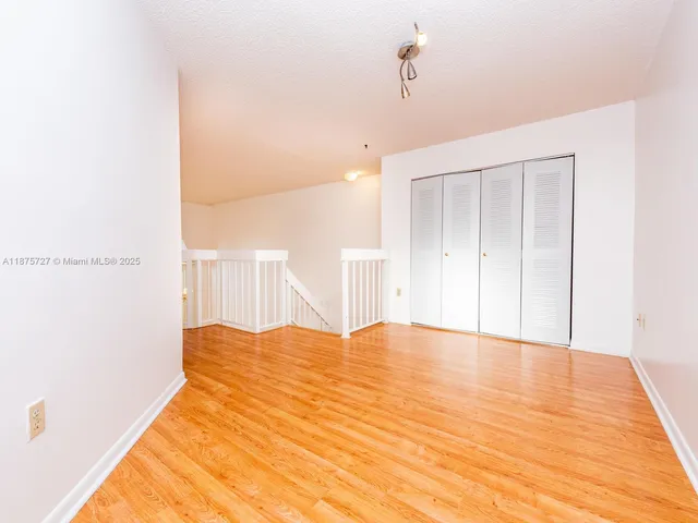 a view of a livingroom with wooden floor and a large window