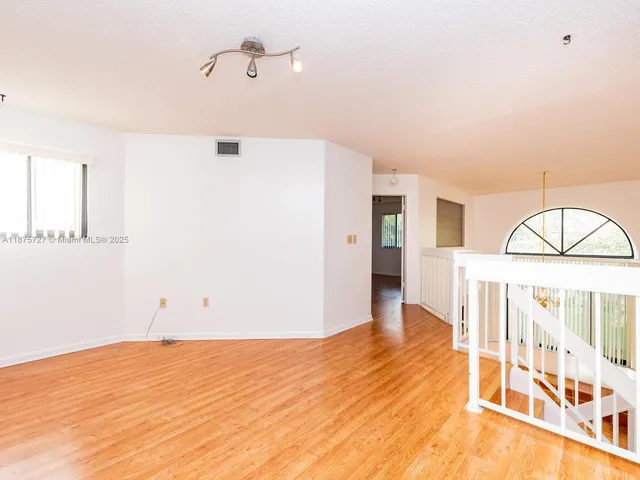 a view of a room with wooden floor and fan
