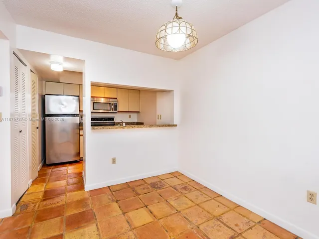 a kitchen with a refrigerator a stove top oven and cabinets