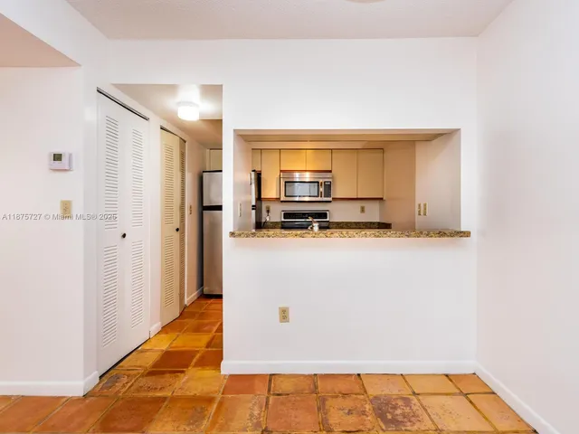 a view of kitchen with refrigerator stove and microwave