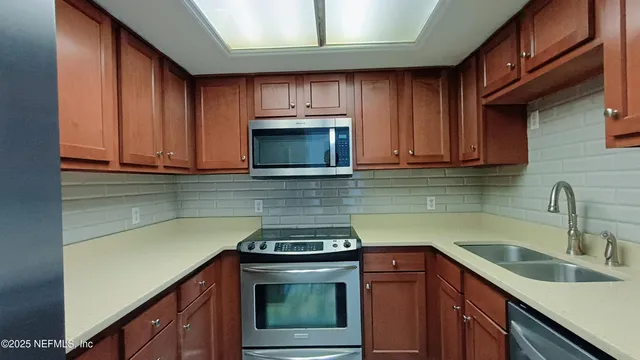 a view of an empty room with wooden floor and stairs