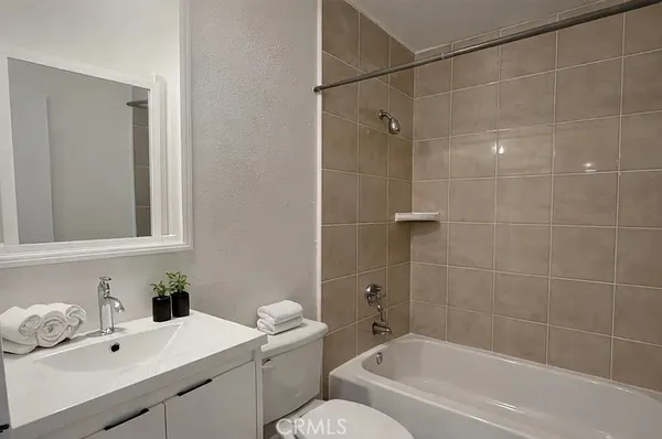 a bathroom with a sink mirror toilet and bathtub