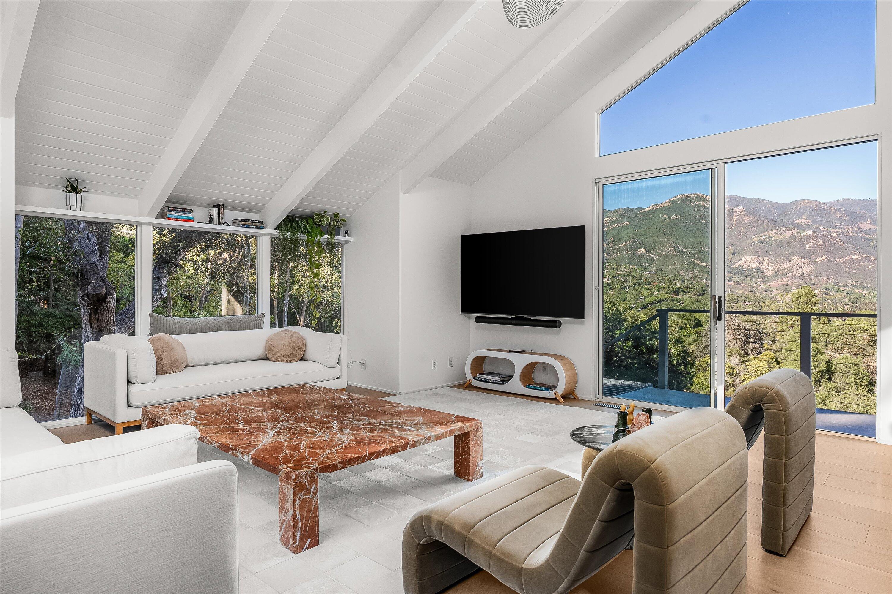 1438 Hillcrest Road Santa Barbara, CA 93103 - Photo 6 of 22 a living room with furniture a flat screen tv and a floor to ceiling window