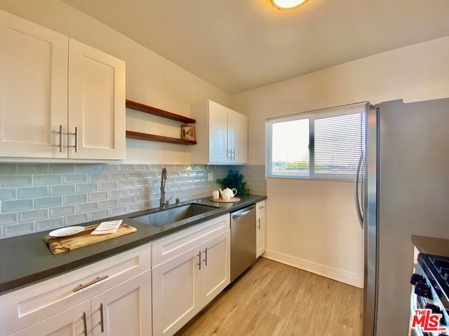 a kitchen with a sink a refrigerator and cabinets
