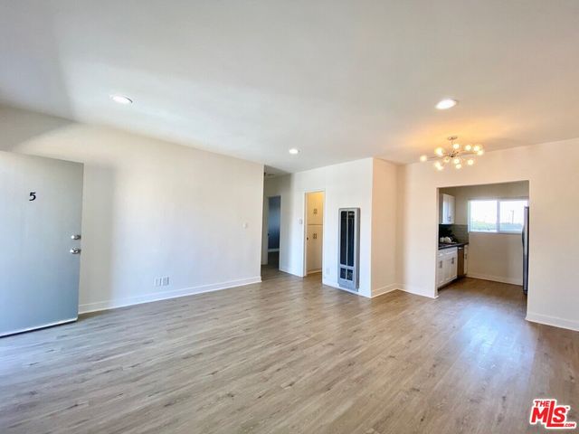 a view of a big room with wooden floor and windows