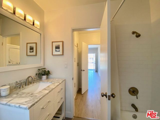 a bathroom with a granite countertop sink a mirror and shower