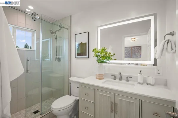 a bathroom with a granite countertop sink a toilet and shower