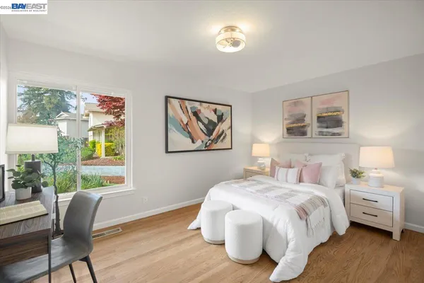 a bedroom with a bed and a painting on the wall