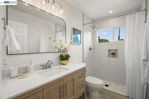a bathroom with a granite countertop sink toilet and shower