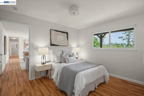 a bedroom with a bed and a wooden floor