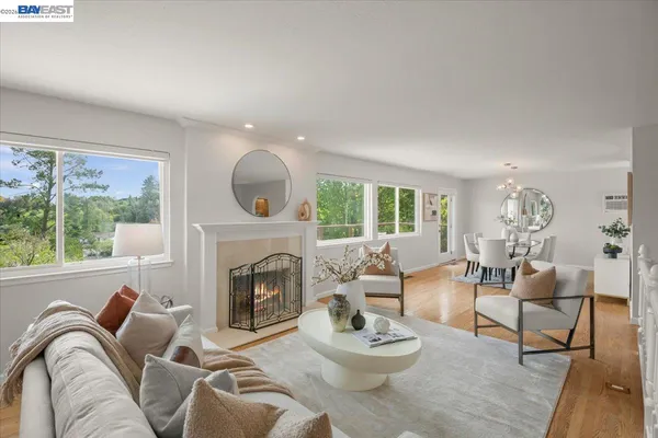 a living room with furniture fireplace and a large window