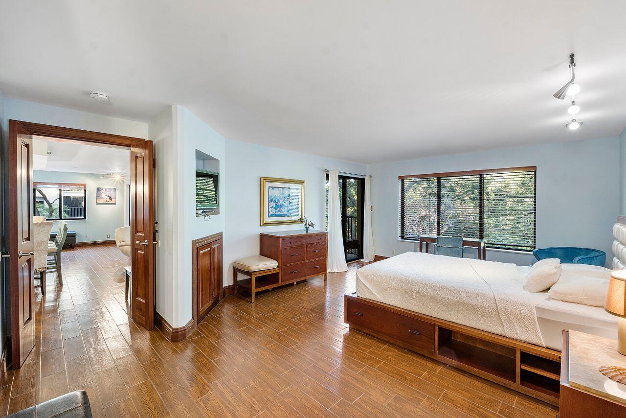 500 Ocean Trail Way, Unit 201 Jupiter, FL 33477 - Photo 19 of 58 a bedroom with a bed and wooden floor