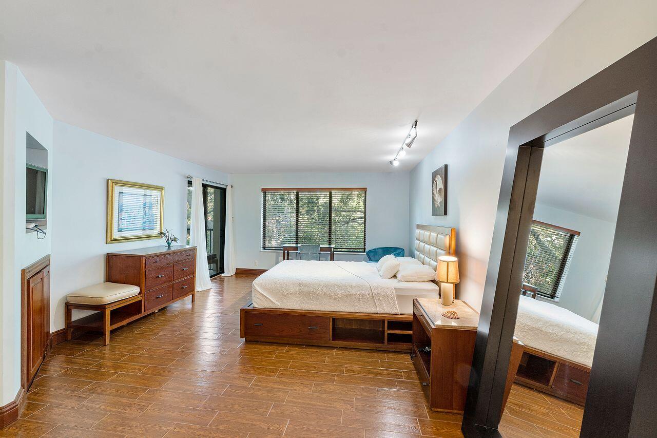 500 Ocean Trail Way, Unit 201 Jupiter, FL 33477 - Photo 20 of 58 a bedroom with a bed and wooden floor