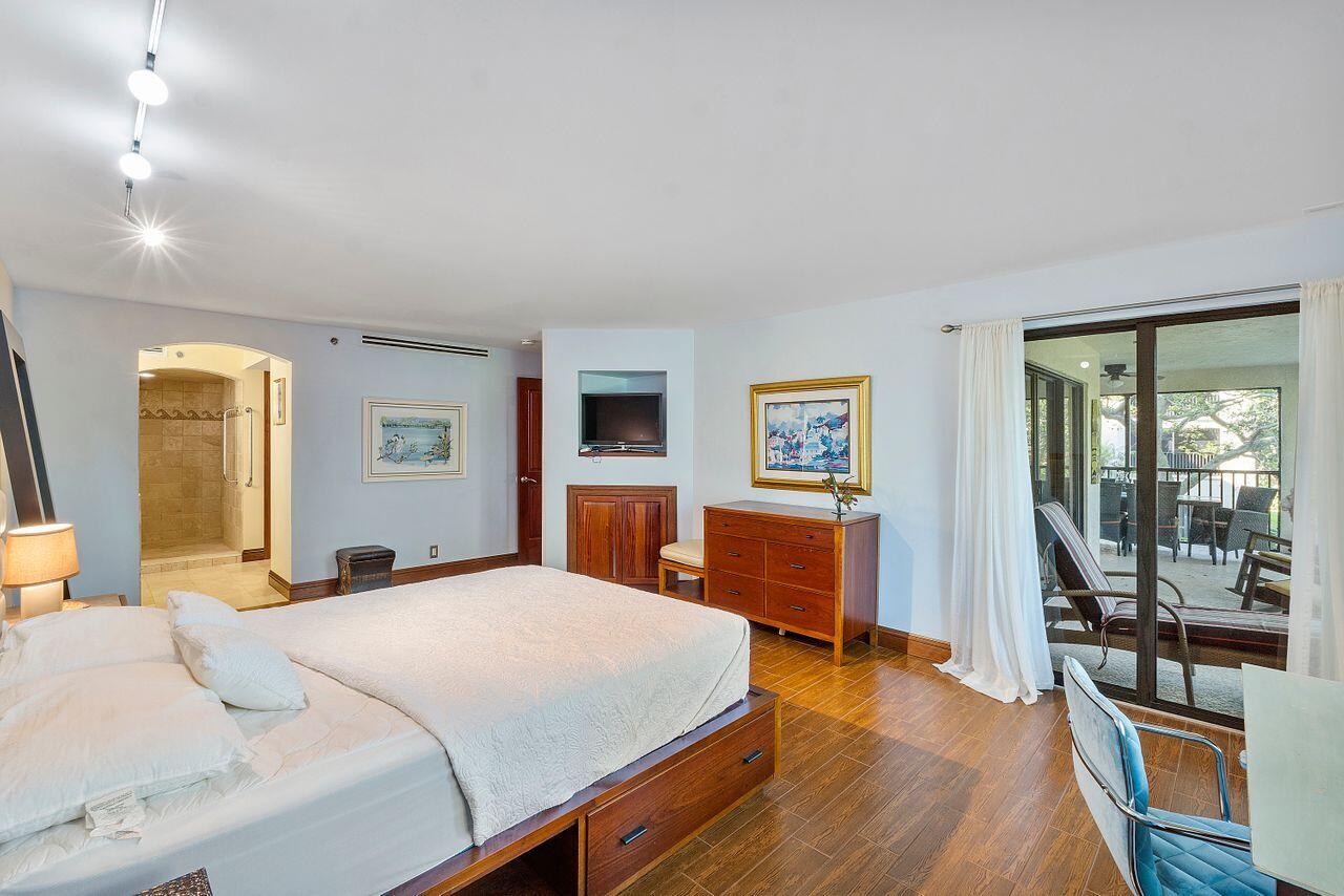 500 Ocean Trail Way, Unit 201 Jupiter, FL 33477 - Photo 21 of 58 a bedroom with a large bed and a flat tv screen