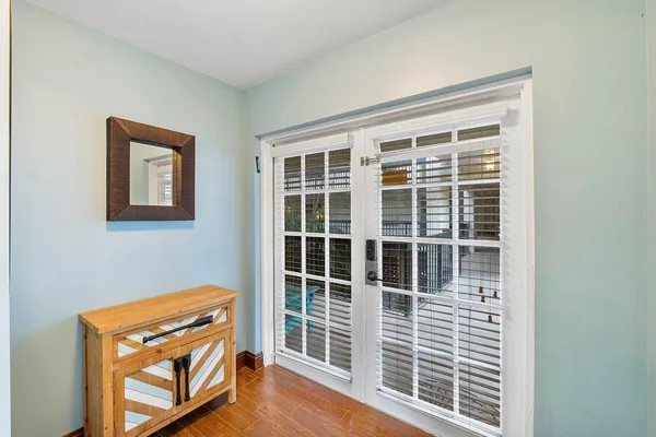 a view of a hallway with wooden floor and windows