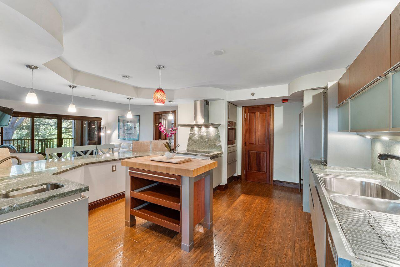 500 Ocean Trail Way, Unit 201 Jupiter, FL 33477 - Photo 8 of 58 a kitchen with granite countertop a sink stove and wooden cabinets